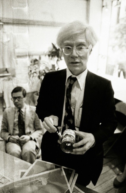 Andy Warhol signing a campbells soup can